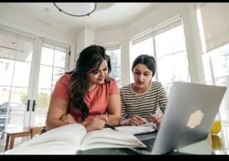 Une maman aidant sa fille à faire ses devoirs