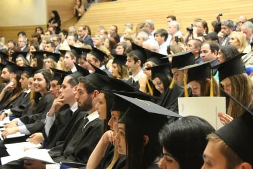 Des étudiants diplômés avec leur chapeau universitaire assis dans un amphithéâtre