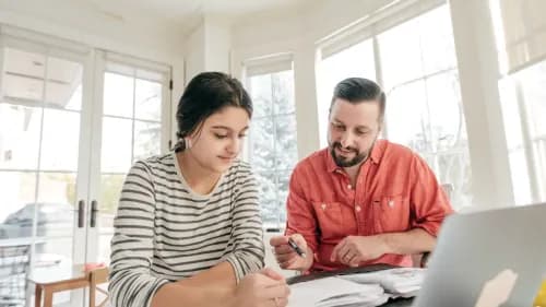 Un père qui aide sa fille à réviser et choisir son orientation scolaire avec l'accompagnement personnalisé de Proxxie.